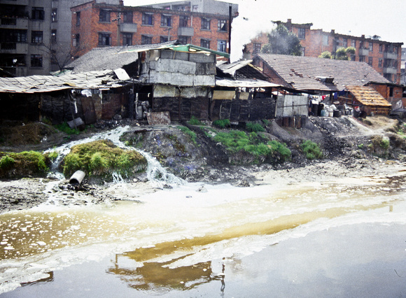 Small factory discharging colorful toxic streams of waste into a tributary of the Jinjiang River