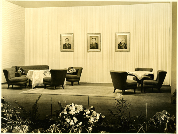 A recreational seating area, with portraits of the three communist world leaders